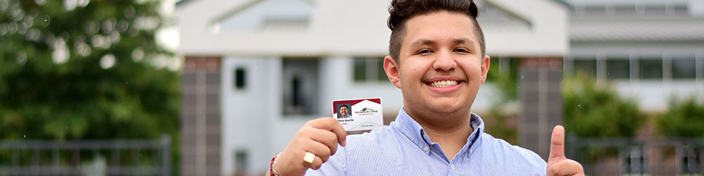 Student proudly displaying her new student I.D.