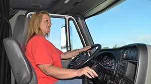 View from passanger-seat of truck driver with her hand on the shifter