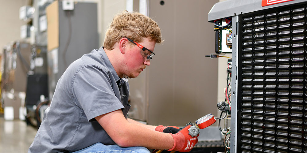Student checking levels on a compressor unit.