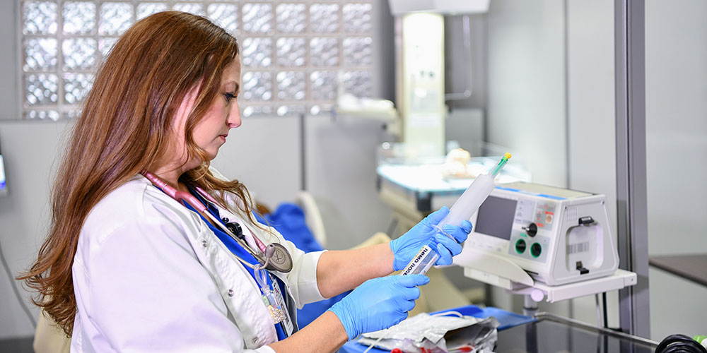 Students practising measuring medication in a mock emergency room.