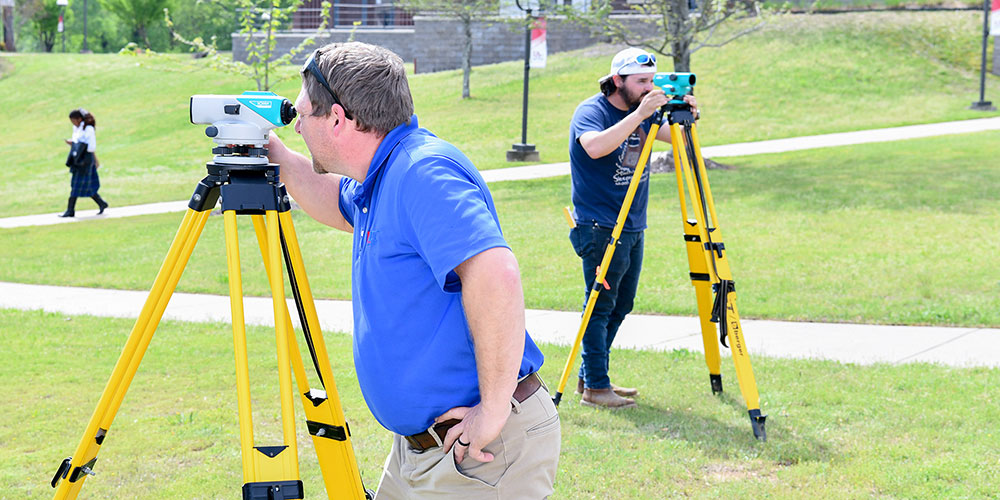 Students practicing taking measurments outside.