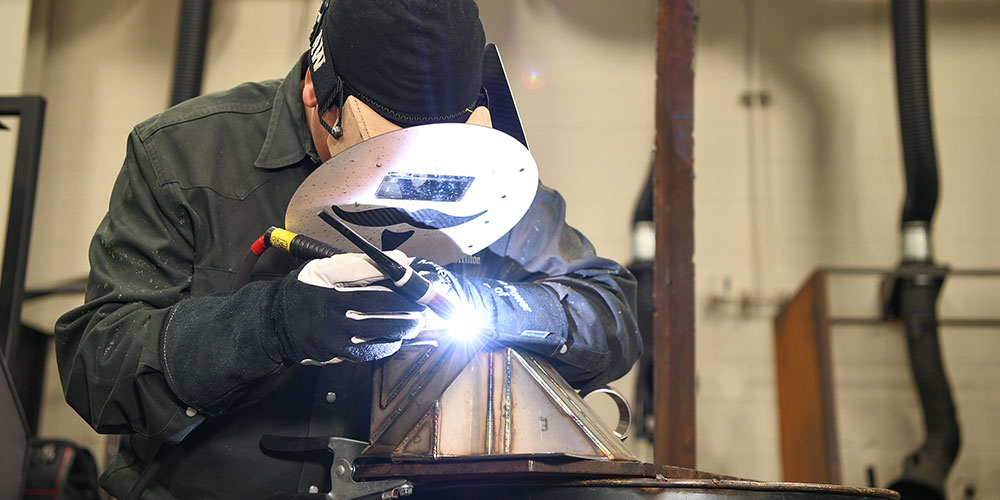 Student in the welding lab practicing welding techniques.